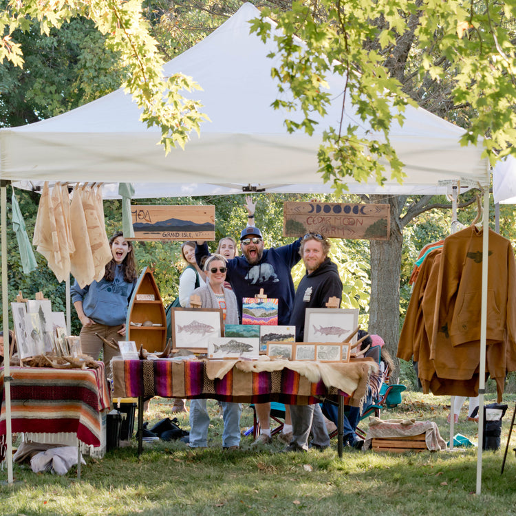 Friends gathered at the Cedar Moon market booth with prints and apparel